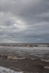 Fototapeta na wymiar Waves crashing onto the beach and sea wall during high tide. Taken in Cleveleys Lancashire England. 