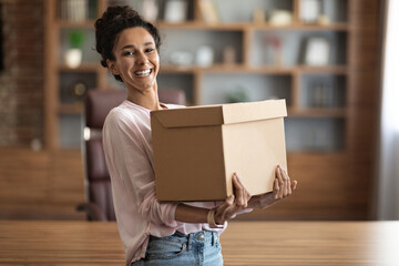 Happy young woman holding box parcel and smiling