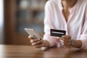 Unrecognizable woman holding cell phone and credit card, copy space