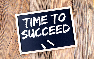 TIME TO SUCCEED text on a chalkboard on the wooden background