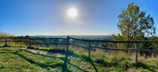 landscape of forests and fields from a slightly higher hill with strong sun