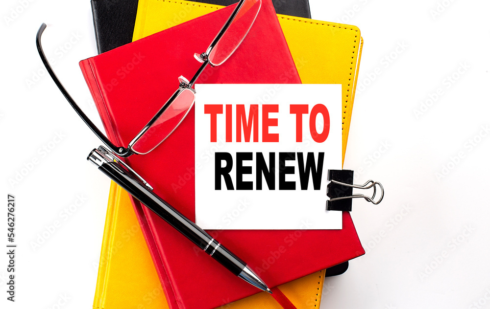 Poster time to renew text written on a sticky on colorful notebooks