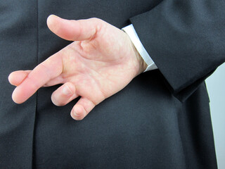 Businessman crossed his fingers behind his back. Good luck or fraud concept.