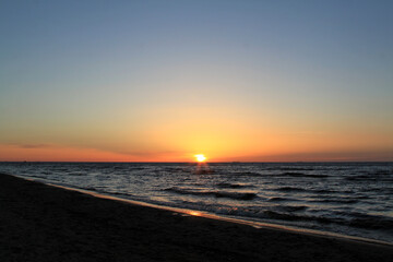 Obraz premium Bronze sunsetting sky above a slightly wavy sea. Selective focus