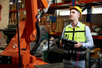 factory worker or engineer operating remote switch controller to control robot machine in the factory © offsuperphoto