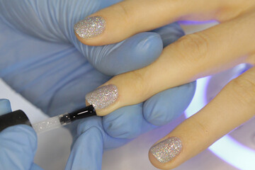 
Workplace of a manicure master. A salon specialist performs work with a client.
Nail technician...