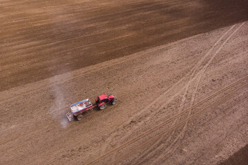 Tractor with fertilizer trailer fertilizes the field after planting. Copy space.Agriculture concept.