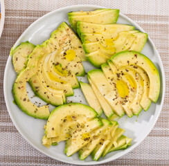 ripe avocado pulp cut into pieces sprinkled with lemon juice on a plate