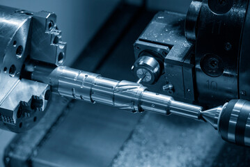 The multi-tasking CNC lathe machine  groove cutting the brass shaft parts by milling spindle. © Pixel_B