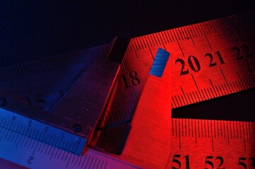caliper and metal rulers illuminated in red and blue. close-up
