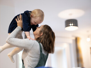 Mother lifting daughter at home