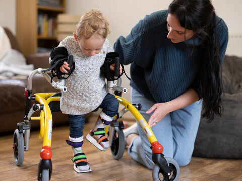 Mother assisting son with cerebral palsy 