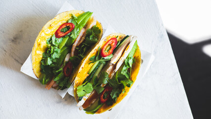 Appetizing tacos on an iron stand on a light background. street food