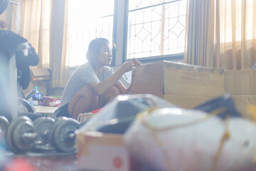 A woman cleaning and clearing unnecessary things out of her room.Natural flare include