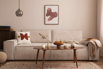 Interior design of living room with mock up poster frame, modern beige sofa, brown braided blanket, wooden coffee table, vase with dried flowers, round pillow, commode, vintage carpet.  Home decor