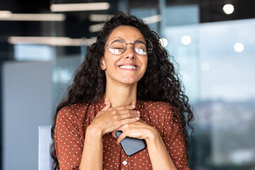 A woman in love is working in the office at work, a Latin American businesswoman in glasses is...