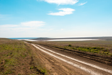 Fototapeta premium Dirt road leading to the sea in summer
