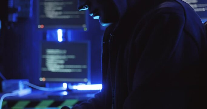 A Hacker Wearing A Mask To Cover His Face Is Using Computer To Hack Data To Get Ransom From Victims.