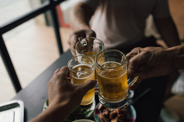 Cheers! Clink glasses. Close-up shots of hands holding beer glasses and beer bubbles.