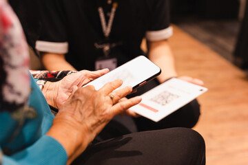 Senior woman paying bill using smart phone scan QR code.
