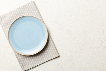 Top view on colored background empty round blue plate on tablecloth for food. Empty dish on napkin with space for your design - Powered by Adobe