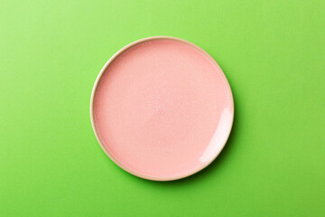 Top view of isolated of colored background empty round pink plate for food. Empty dish with space for your design
