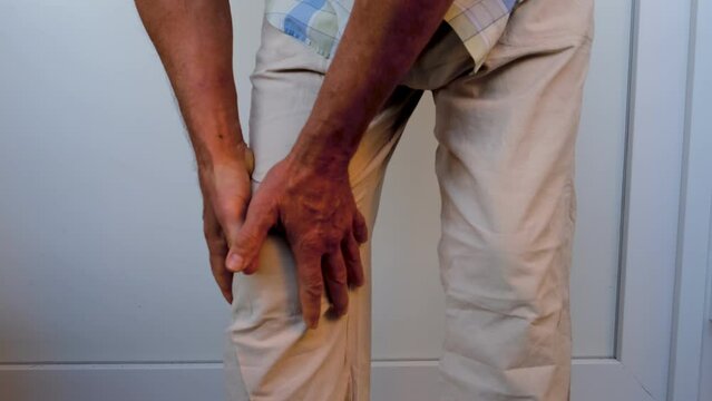 closeup male hand on knee, mature man with joint pain, senior 60 years old is sick, concept health, diagnosis, treatment diseases ligament injury, torn meniscus, fracture, Knee bursitis