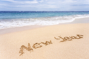 New Year written on the sand on the beach