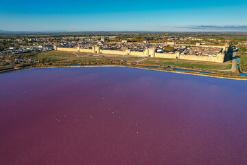 Aerial sunset view above the stunning pink salt lake full of flamingoes in front of Aigues Mortes in southern France