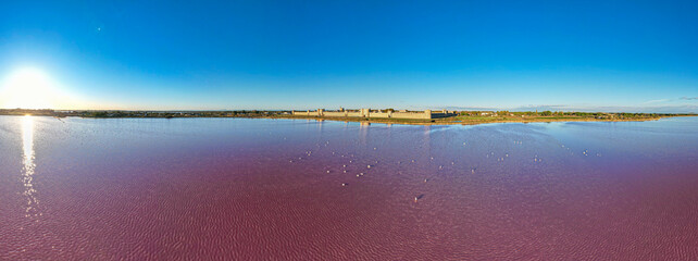 Aerial sunset view above the stunning pink salt lake full of flamingoes in front of Aigues Mortes in southern France