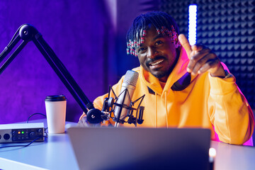 Happy young african man audio blogger broadcasting at studio