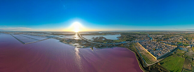 Aerial sunset view above the stunning pink salt lake full of flamingoes in front of Aigues Mortes in southern France