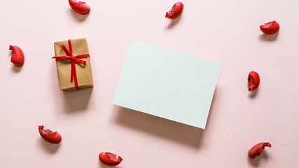 white blank card , gift box , rose petals on pink background