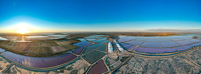 Aerial view of the production of the Sel de Camargue and the Fleur de Sel in the south of France near Aigues Mortes. Different colour salt lagoons including bright pink lakes