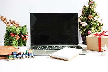 Laptop computer with Christmas decorations on white background
