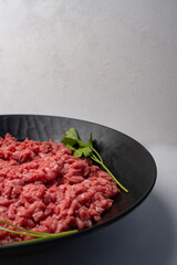 Chopped raw meat. Cut beef into small pieces on blake plate