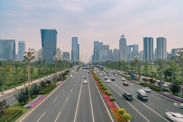 Obraz premium Aerial shot of a wide street in Shanghai full of cars with high skyscrapers on the background