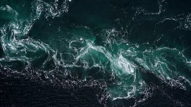 4K drone video with birds-eye view of the abstract and powerful water currents, rapids and whirlpools of the worlds larges maelstrom Saltstraumen, Norway.