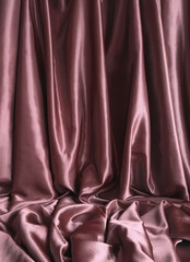 Elegant smooth claret red satin, silk fabric drapes. Luxurious cloth textile with liquid wave....