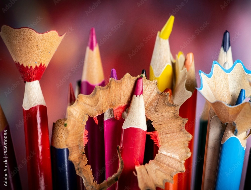 Poster selective focus on colorful sharpened pencils on a red background