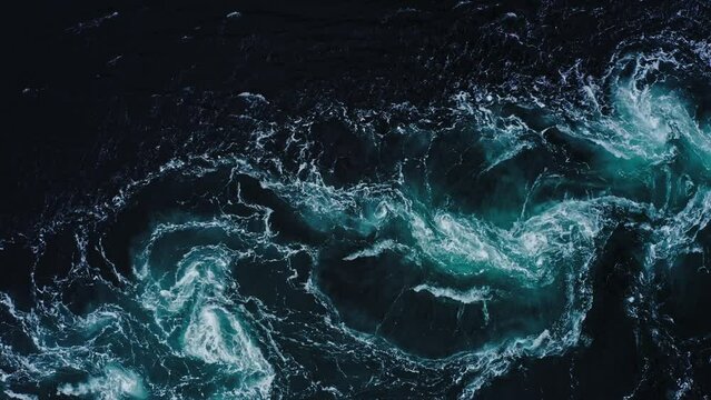 4K drone video with birds-eye view of the abstract and powerful water currents, rapids and whirlpools of the worlds larges maelstrom Saltstraumen