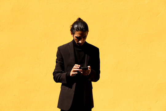 Hispanic man in suit using smartphone