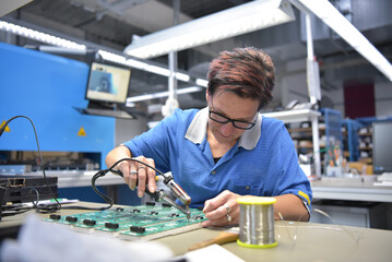 friendly woman working in a microelectronics manufacturing factory - component assembly and...