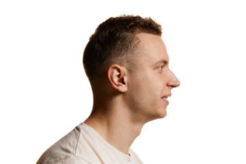 Fototapeta premium Side view portrait of man in white T-shirt posing isolated over white studio background. Stylish haircut and smooth face. Concept of men's health, body and skin care