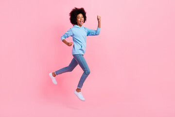 Fototapeta na wymiar Full length profile portrait of delighted astonished person jumping raise fists isolated on pink color background