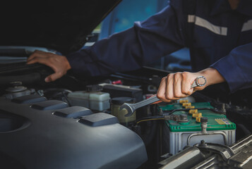 Auto mechanic working on car engine in mechanics garage. Repair service.	