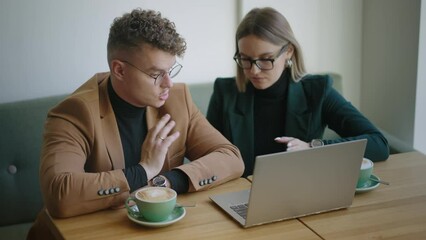 man and woman managers are discussing new project and sales graphics on laptop screen