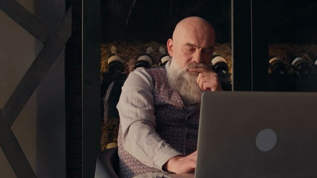 owner of a liquor store is working on his store's laptop.