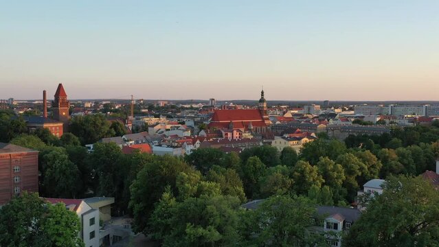 High-angle video panning over Cottbus city with the golden evening sun setting on the horizon