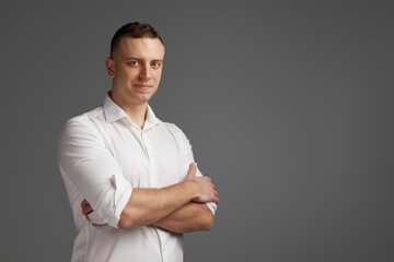 Portrait of young man posing in white shirt isolate dover grey studio background. Businessman. Startup. Success